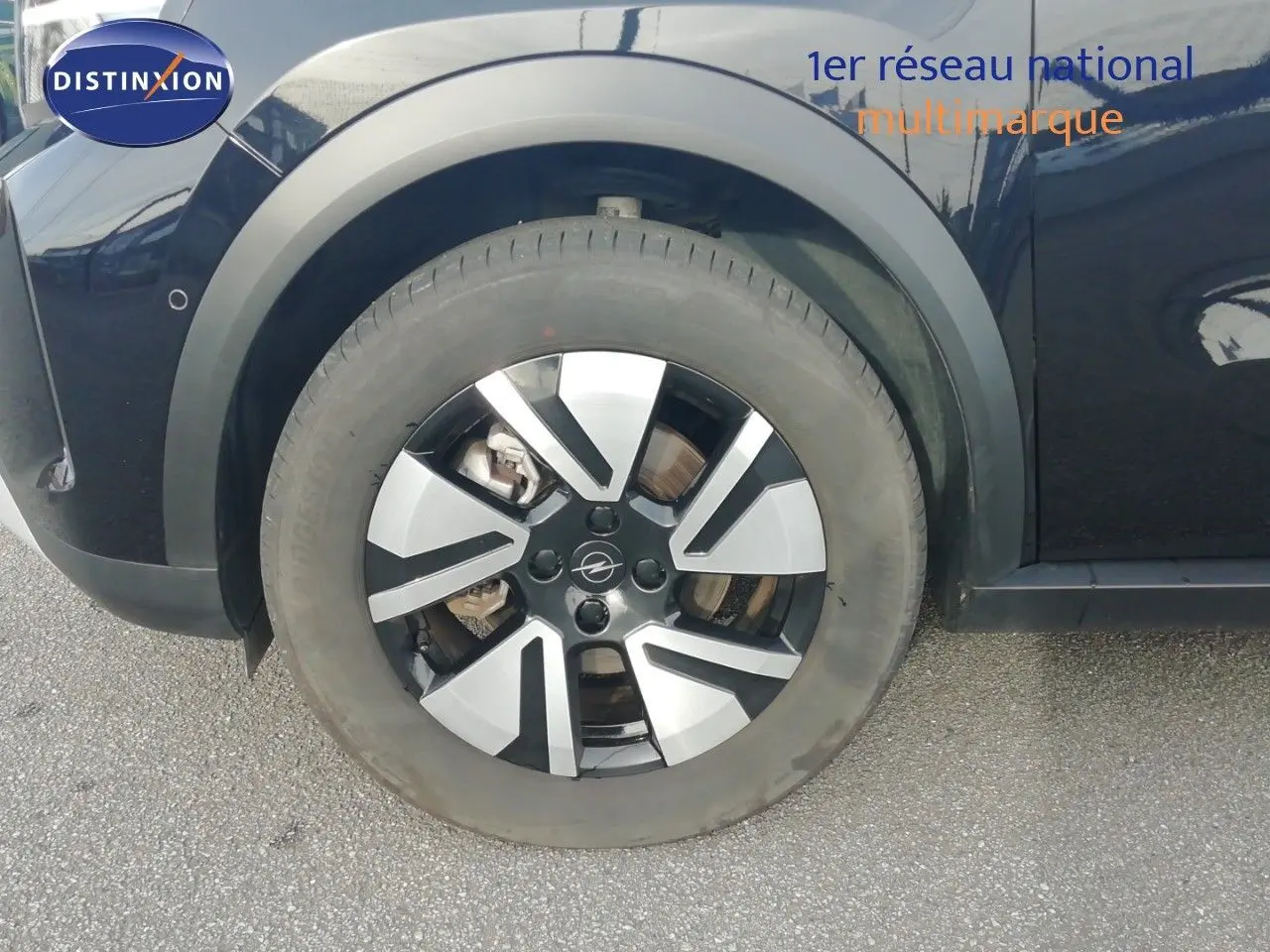 Gros plan sur la roue avant gauche noire Karbon de l'Opel Frontera 2025 avec jante alliage bicolore.