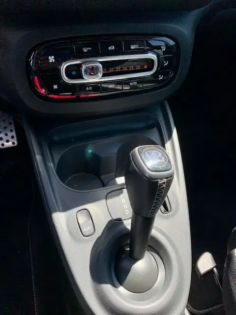 Gros plan sur la console centrale d'une Smart Fortwo électrique grise 2019, mettant en valeur le levier de boîte automatique Brabus.