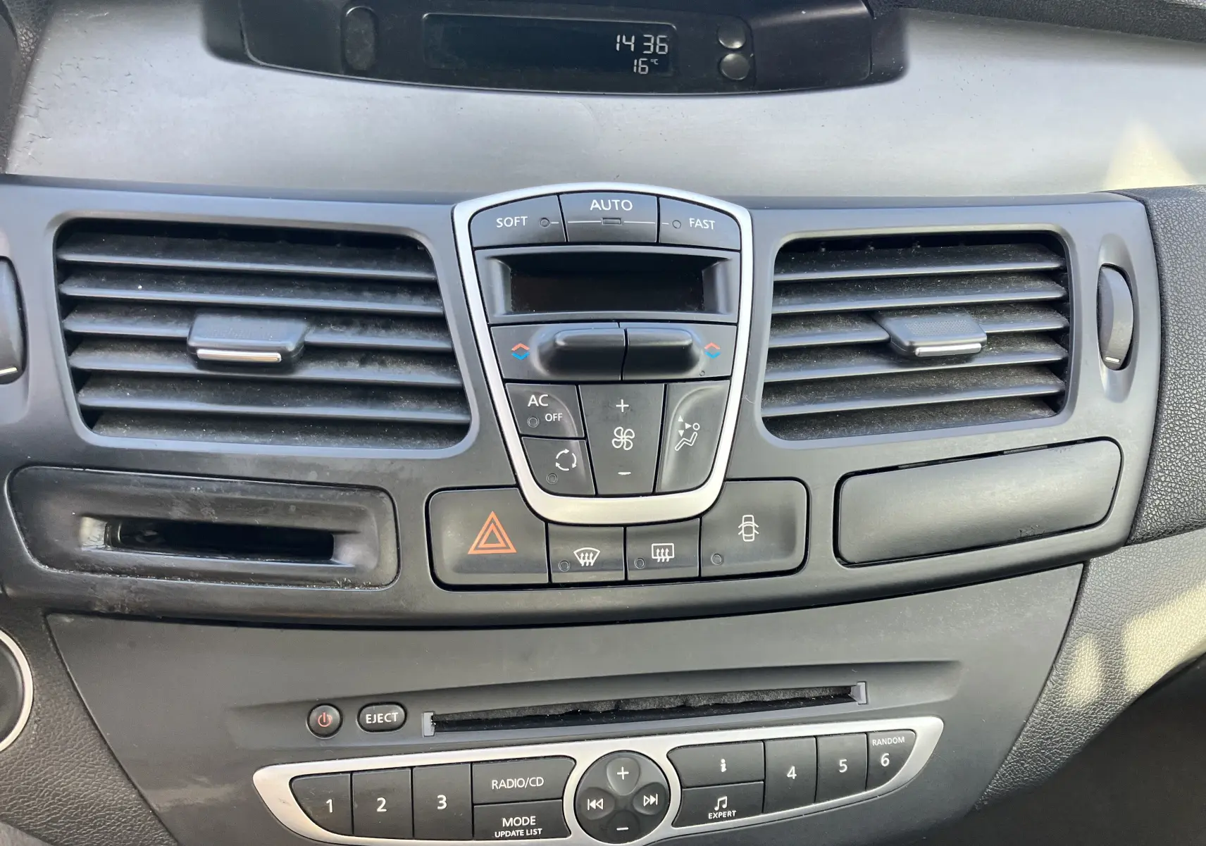 Tableau de bord gris foncé de Renault Laguna 1.5l dCi 2008 avec commandes climatisation et radio intégrées.