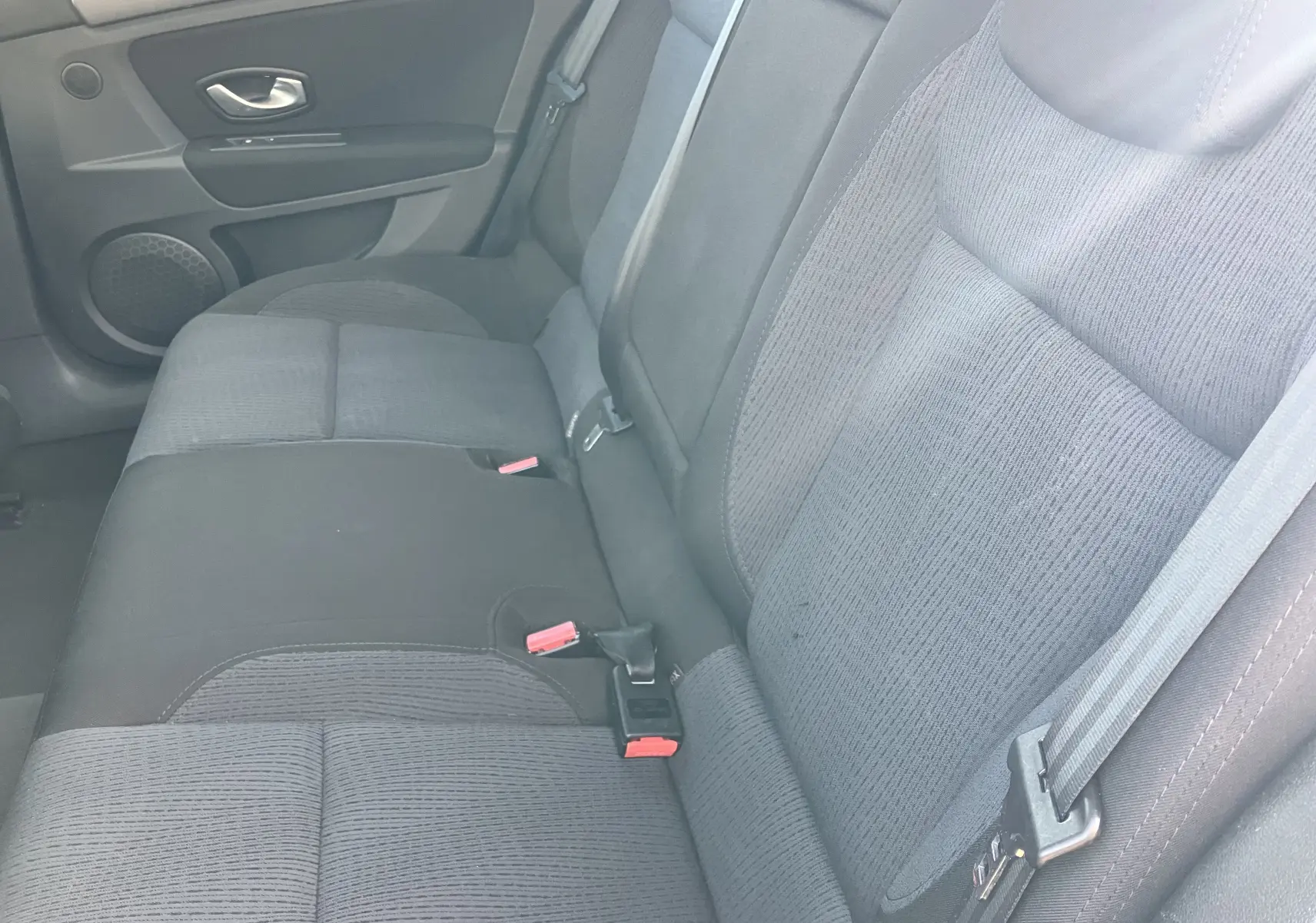 Vue rapprochée des sièges arrière en tissu noir de la Renault Laguna 1.5l dCi 2008 avec ceintures de sécurité visibles