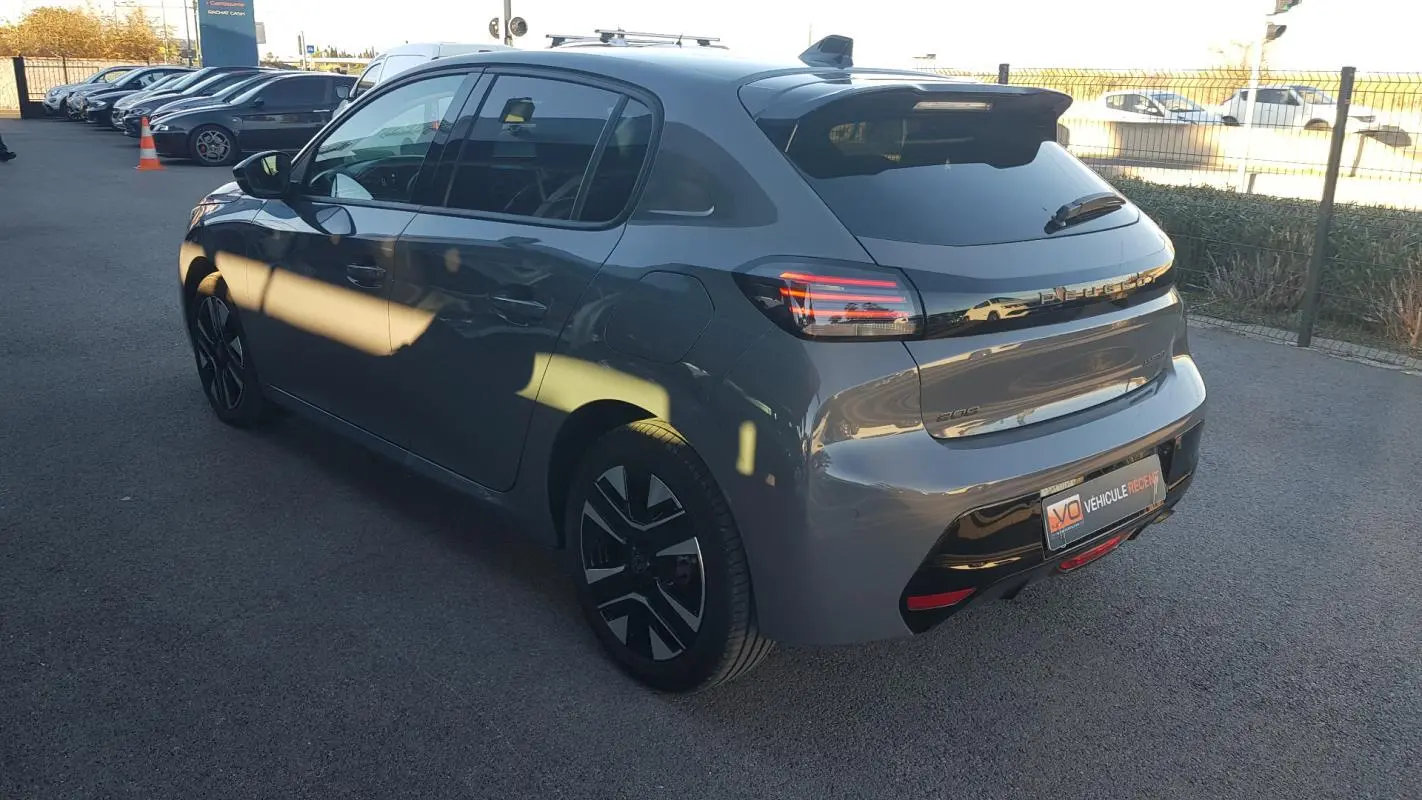 Peugeot 208 gris vue 3/4 arrière droit, jantes alliage 16 pouces et feux arrière LED distinctifs.