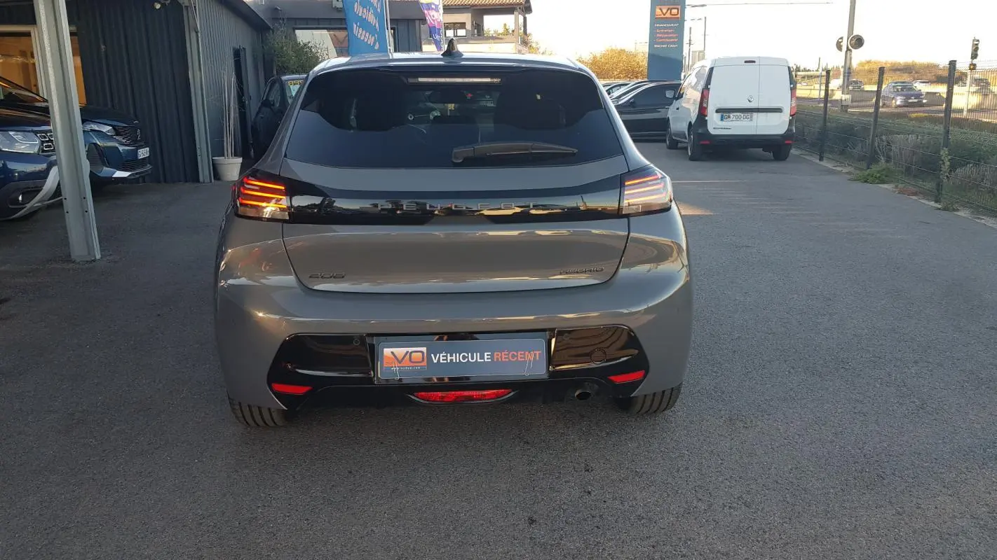 Vue arrière d'une Peugeot 208 Hybrid 100 e-DCS6 Allure gris, avec feux LED allumés et jantes alliage 16 pouces.