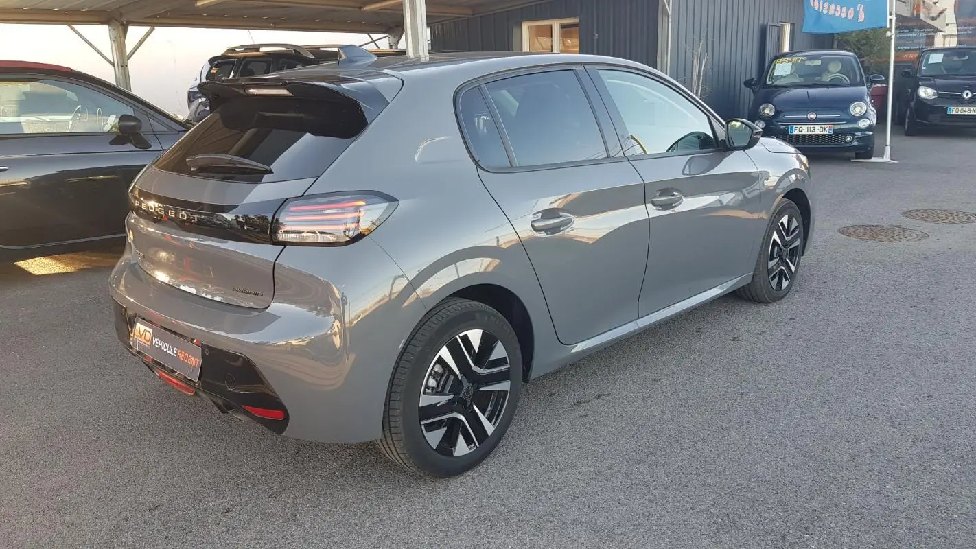 Vue 3/4 arrière droite d'une Peugeot 208 Hybrid gris métallisé avec jantes alliage et feux arrière LED.