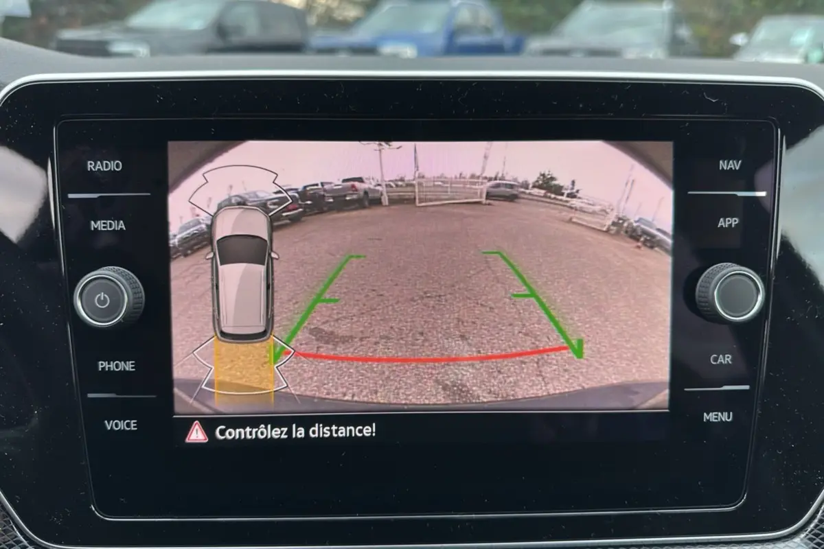Vue de l'écran de caméra de recul du Volkswagen T-cross noir intense, avec guidage de trajectoire et alerte de distance.