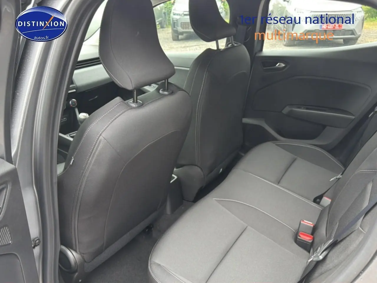 Vue intérieure arrière de la Renault Clio V gris schiste, montrant la banquette arrière et le dossier des sièges avant.