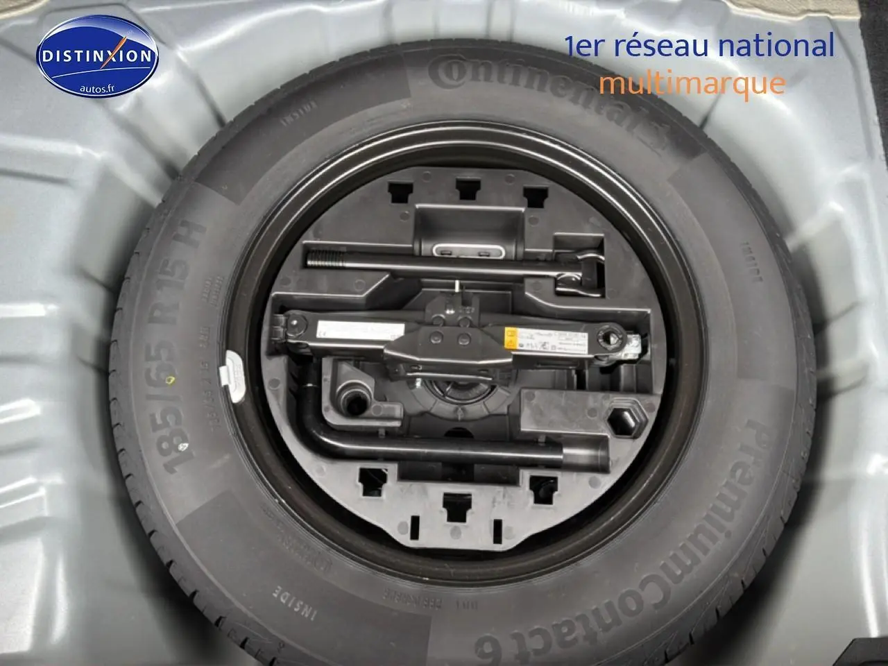 Roue de secours avec outillage intégré dans le coffre d'une Renault Clio V gris schiste, vue de dessus.
