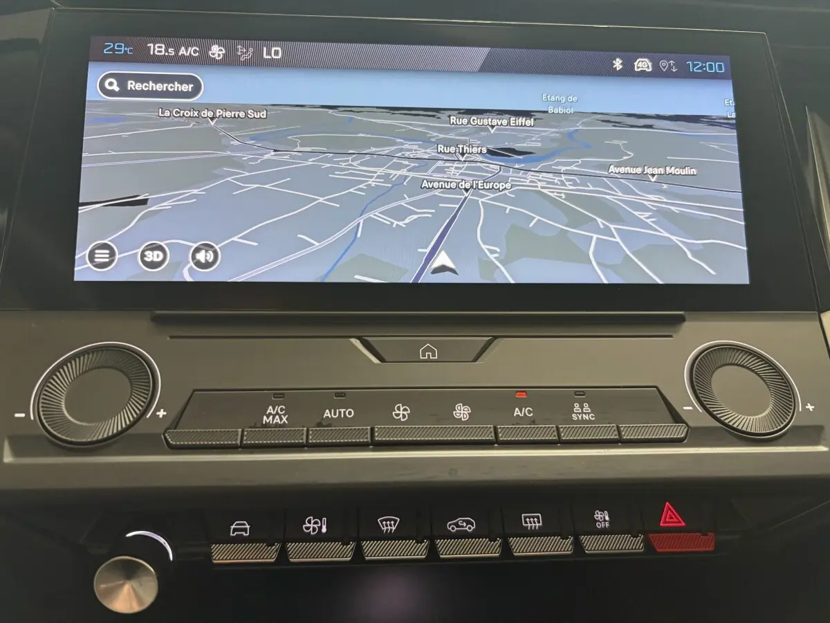 Vue rapprochée de l’écran tactile central et des commandes de climatisation du tableau de bord de la Peugeot 308 blanche 2024.