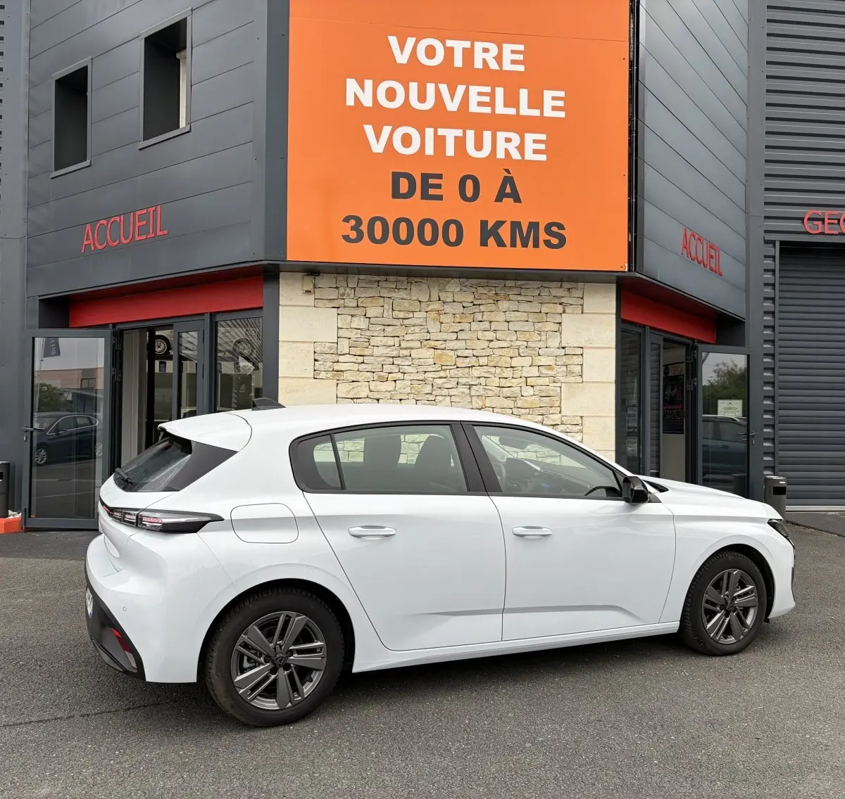 Peugeot 308 blanche vue de profil côté droit, avec rétroviseurs ton caisse et jantes alliage foncé.