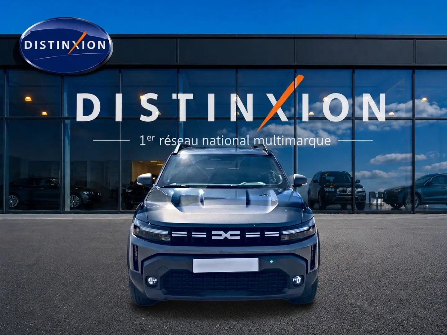Vue avant du Dacia Duster 1.2 mild hybrid 140 Journey gris schiste avec calandre et phares LED distinctifs.