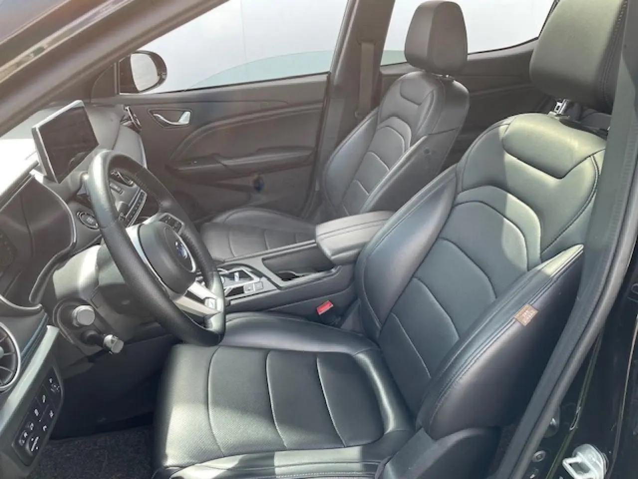 Intérieur côté conducteur du SERES 3 Luxury 2022 en similicuir noir, avec tableau de bord et écran tactile visible.