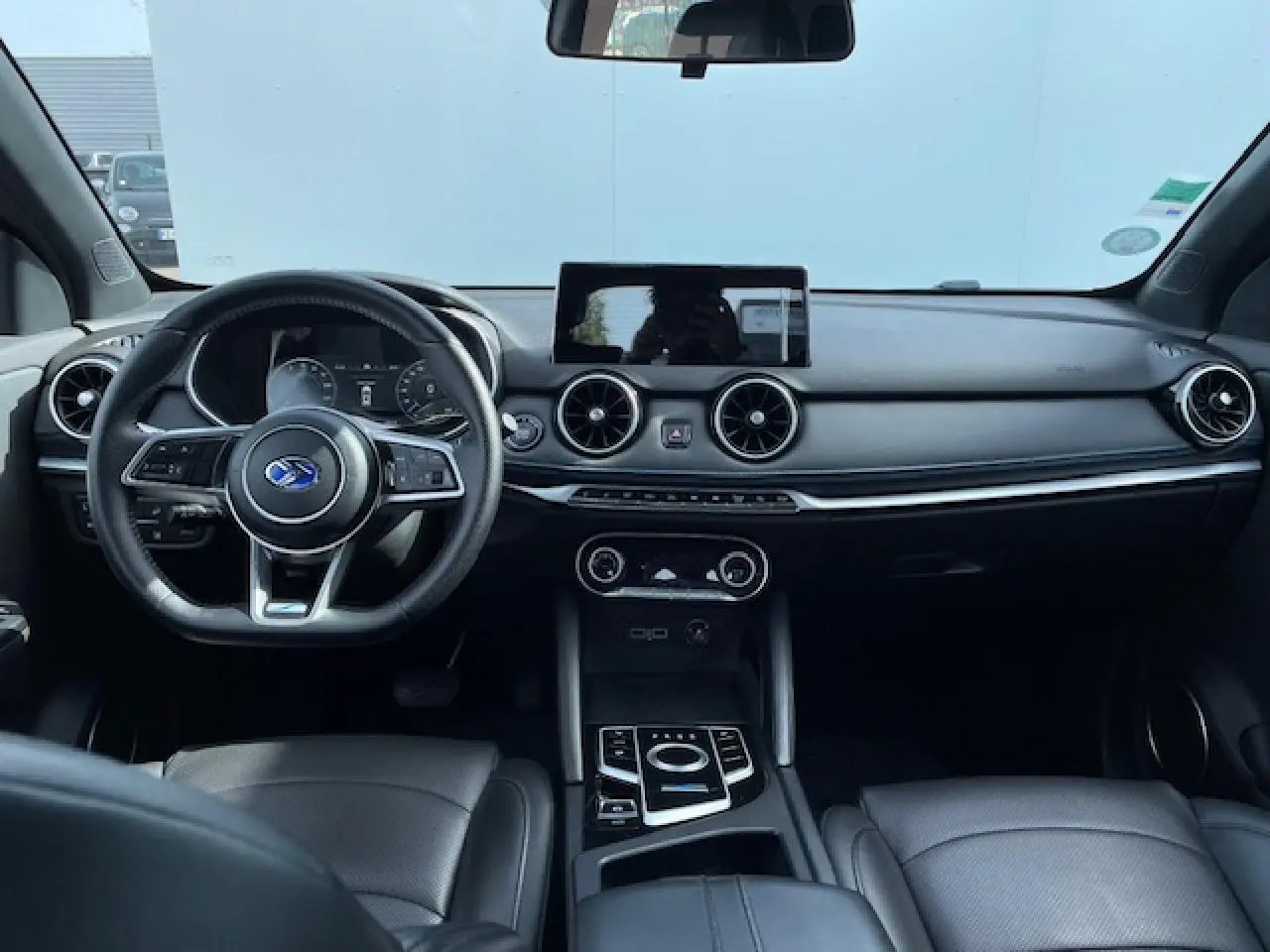 Vue intérieure avant du SERES 3 Luxury 2022 avec tableau de bord noir, volant multifonction et écran tactile central.