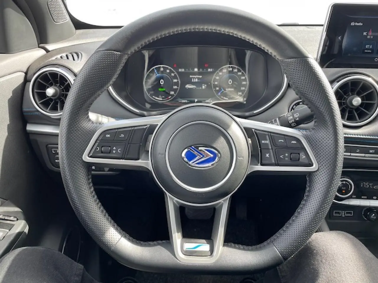 Vue centrée sur le volant en cuir perforé du SERES 3 Luxury noir métal avec tableau de bord numérique et écran tactile.