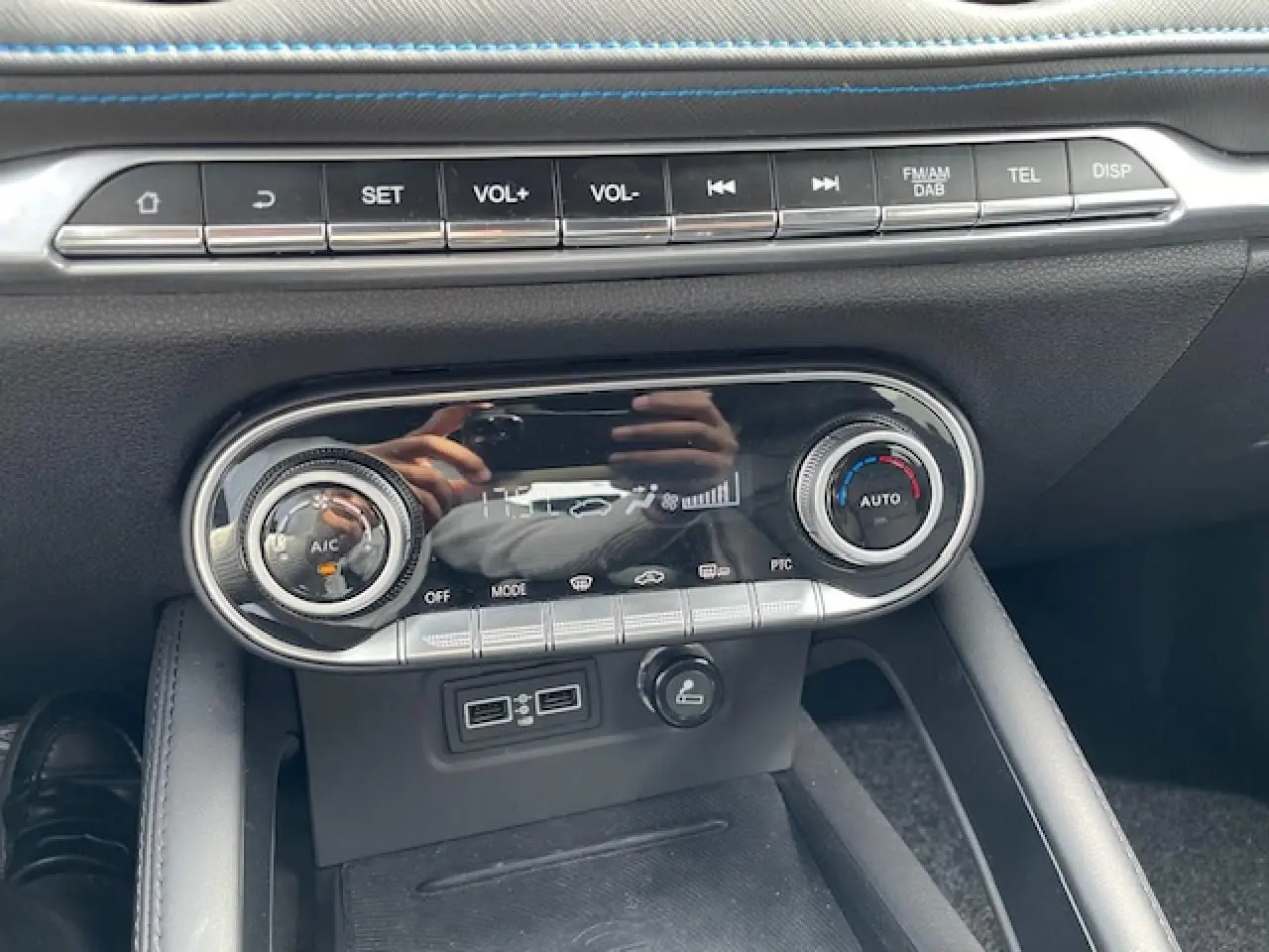 Détail de la console centrale noire du SERES 3 Luxury 2022 avec commandes climatisation et ports USB visibles.