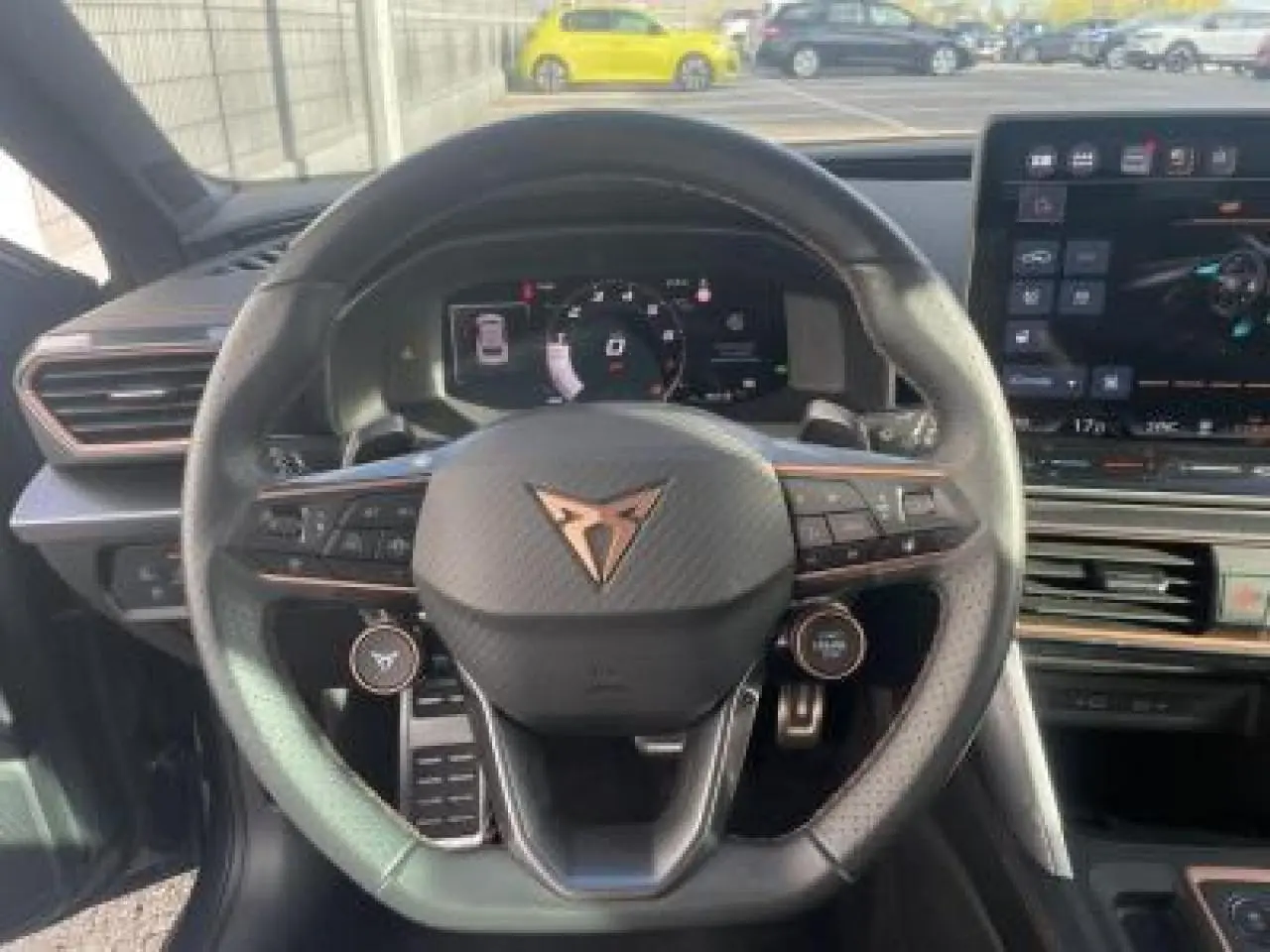 Vue centrée sur le volant cuir noir du CUPRA Leon 2025 avec logo cuivré et tableau de bord digital visible