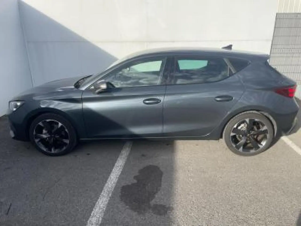 Profil côté gauche d'une CUPRA Leon 2025 gris magnetic metal avec jantes alliage noires et lignes dynamiques.