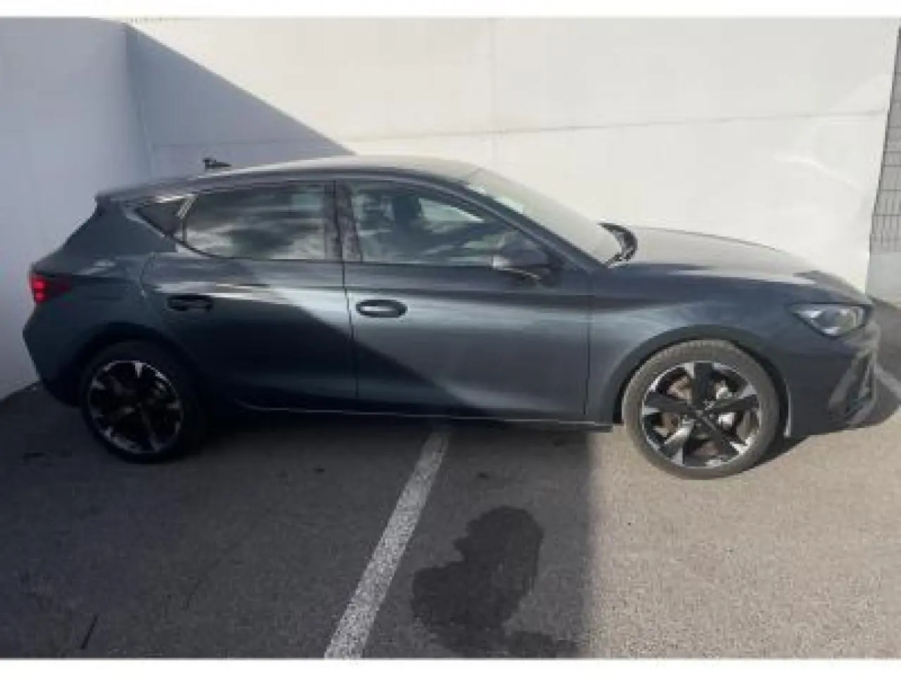 Profil côté gauche de la CUPRA Leon 2025 gris Magnetic Metal avec jantes alliage noires et vitres surteintées.