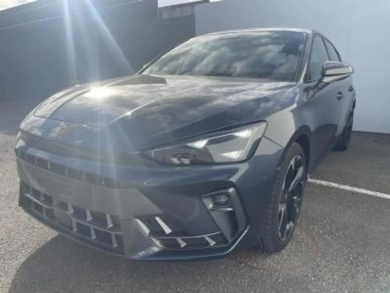 Vue 3/4 avant d'une CUPRA Leon 2025 gris magnetic metal avec jantes alliage noires et signature lumineuse Tri-LED.