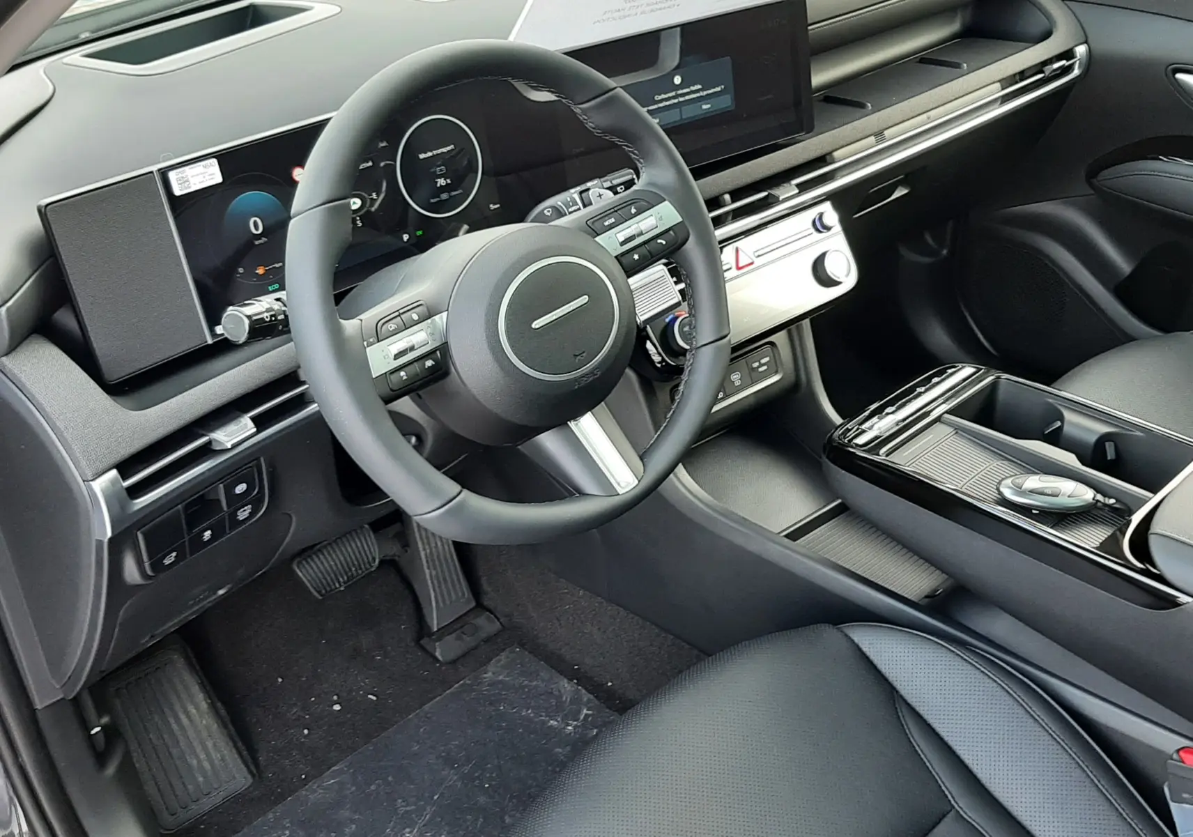 Intérieur noir du Hyundai Tucson 2025, vue côté conducteur sur tableau de bord numérique et volant multifonction.