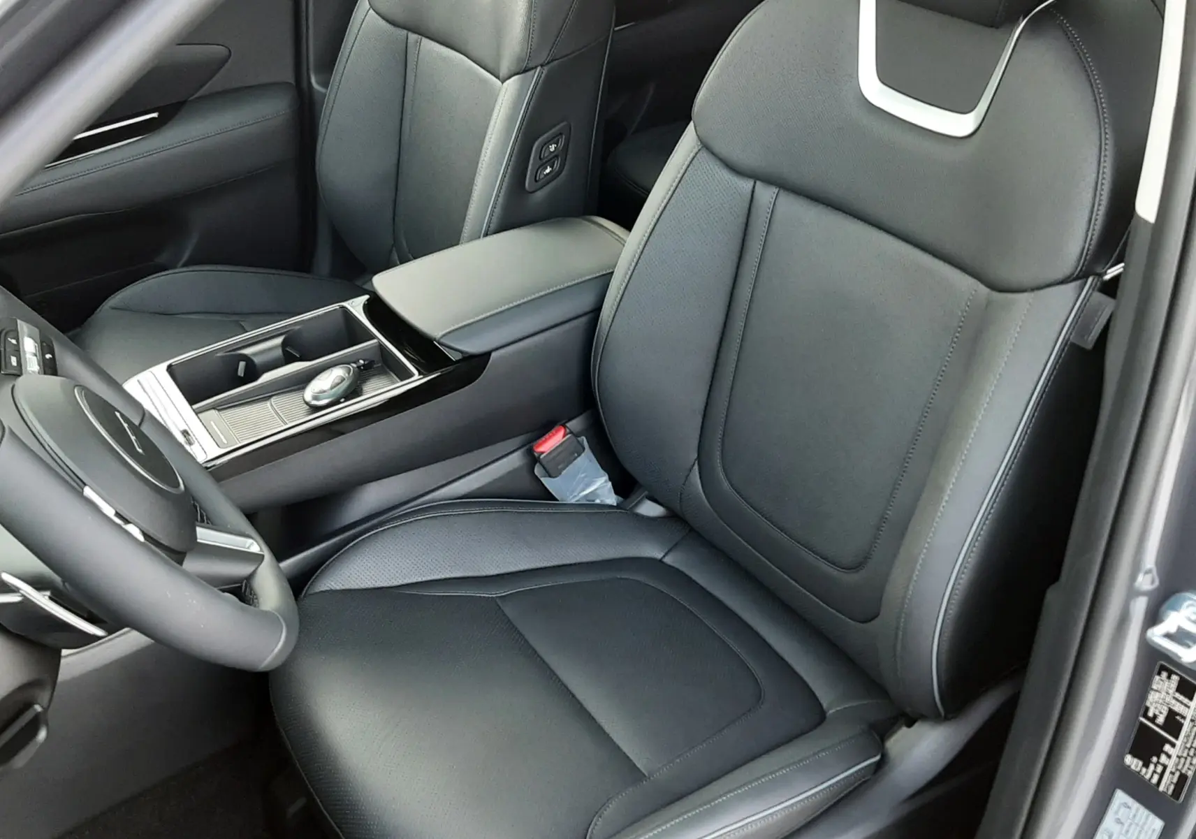 Intérieur noir du Hyundai Tucson 2025 vu côté conducteur, avec sièges en cuir et console centrale moderne.