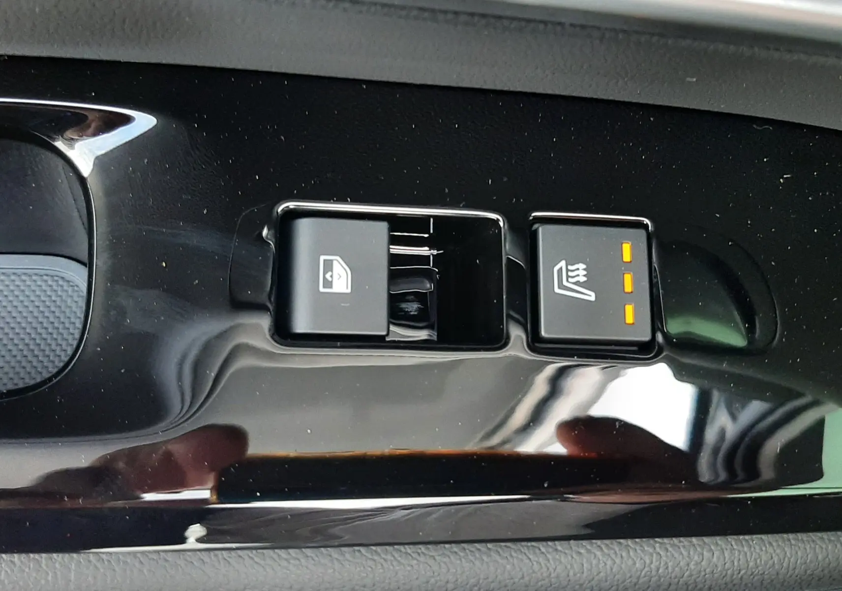 Gros plan sur les boutons de commande de la fenêtre et siège chauffant côté conducteur du Hyundai Tucson gris Ecotronic 2025.