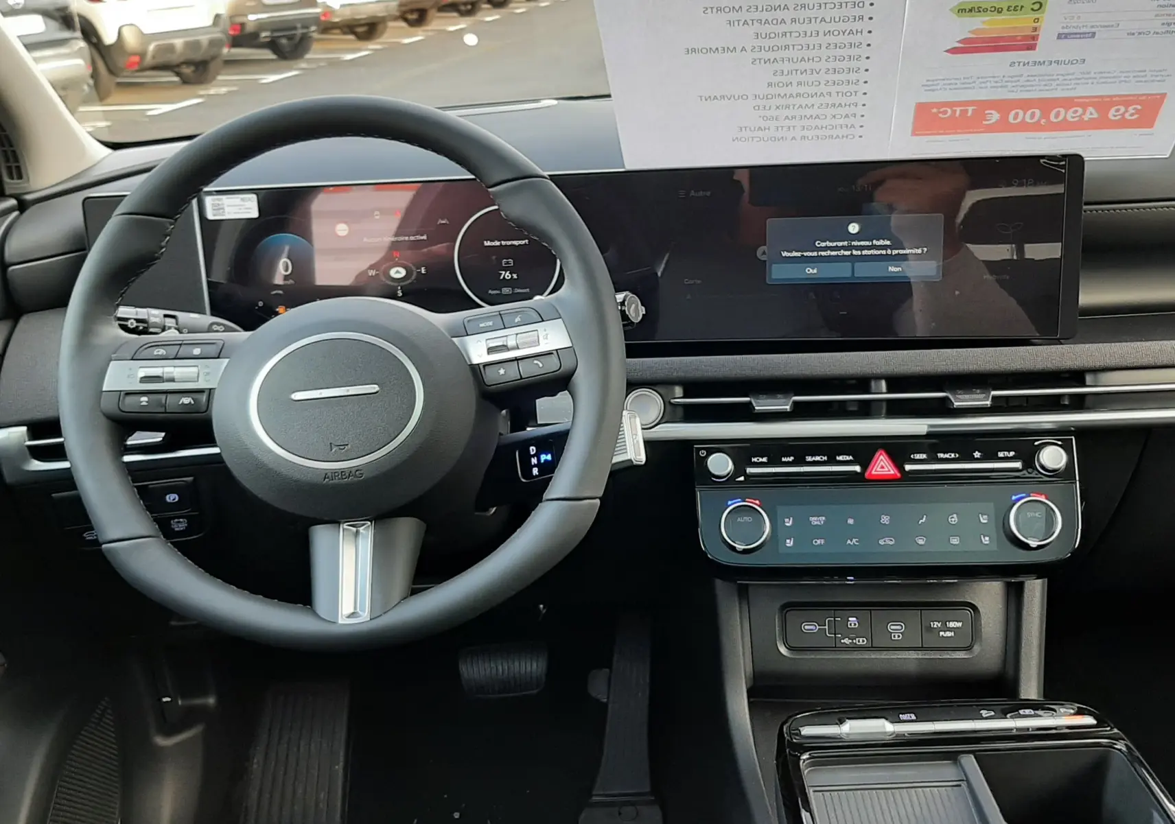 Vue intérieure du tableau de bord et volant noir du Hyundai Tucson 2025 avec écran digital panoramique et commandes intégrées.