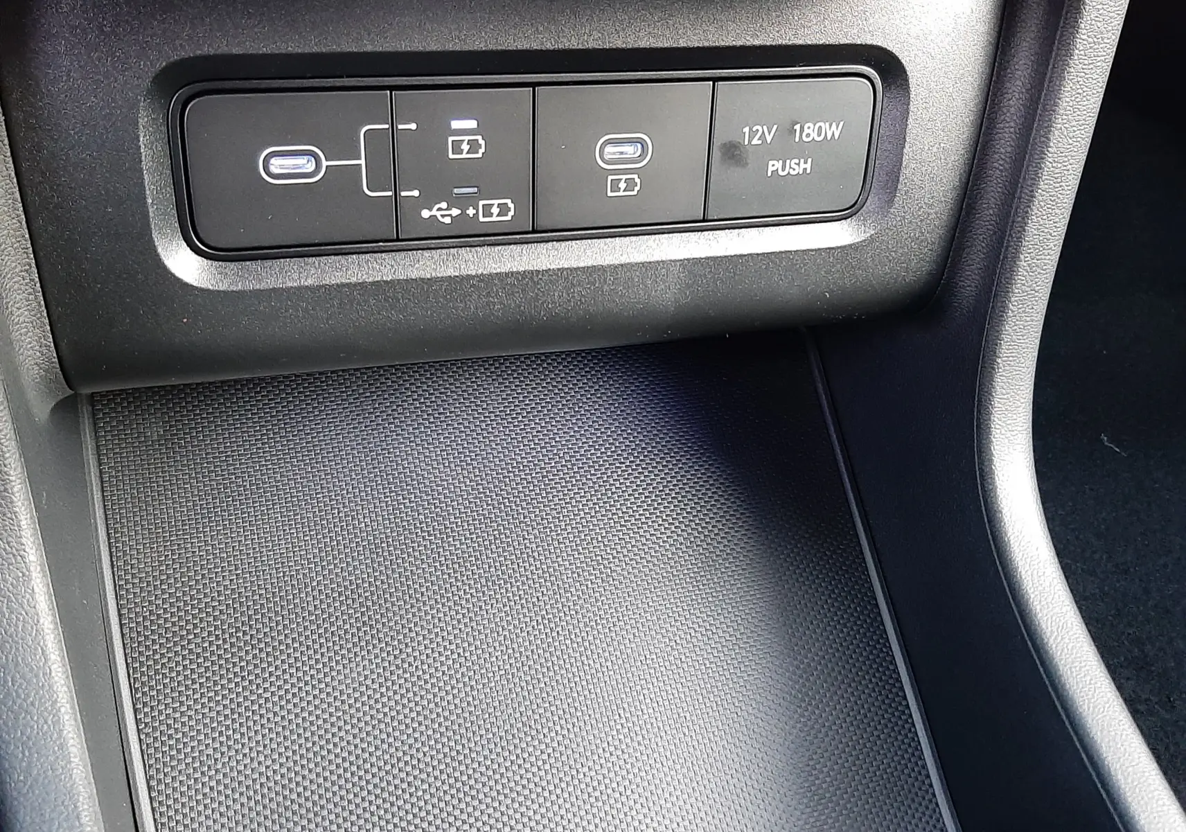 Prise USB-C et port 12V dans la console centrale du Hyundai Tucson 2025 finition Executive en intérieur noir.