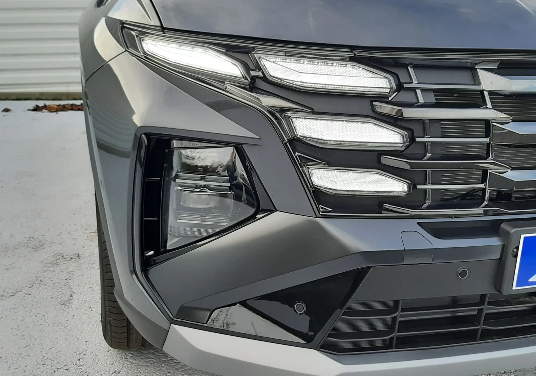 Gros plan sur l'avant gauche du Hyundai Tucson 2025 gris Ecotronic, mettant en valeur ses phares LED Matrix et sa calandre distinctive.