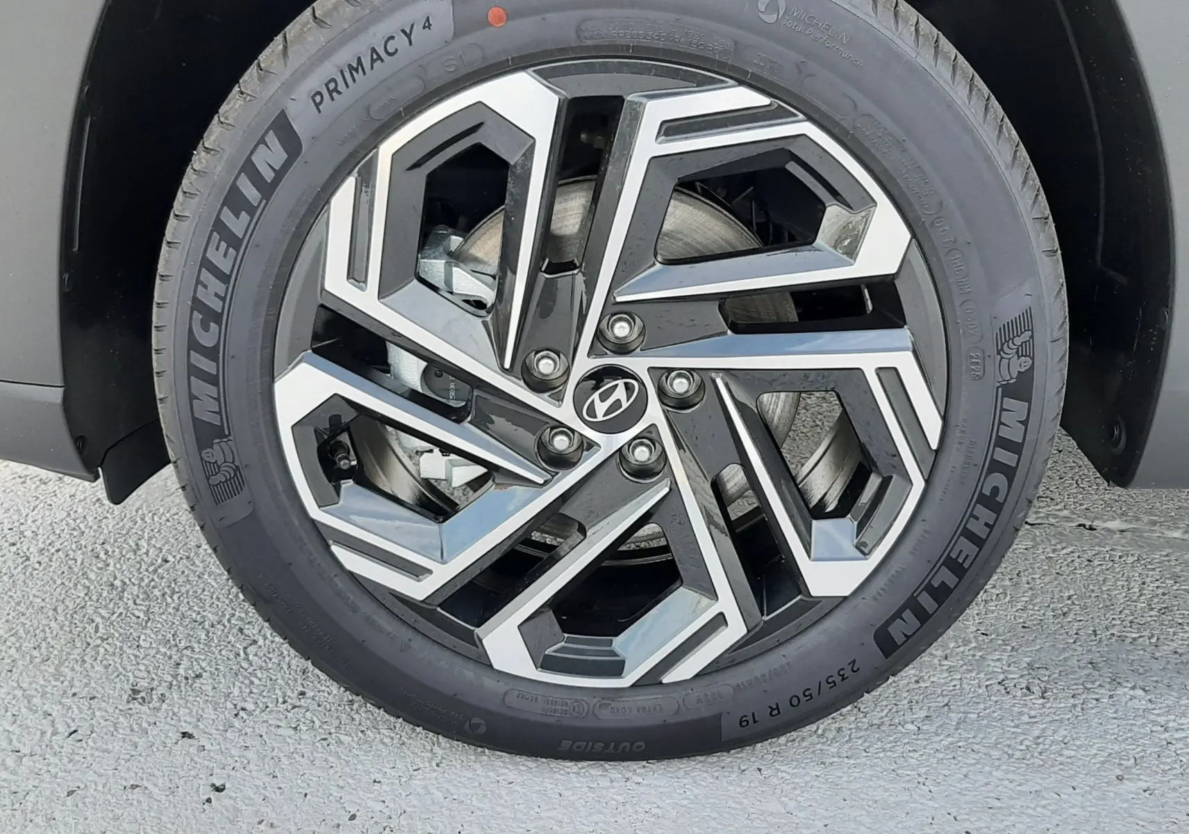 Gros plan sur la jante alliage 19" noire et argentée du Hyundai Tucson 2025 Ecotronic Grey.