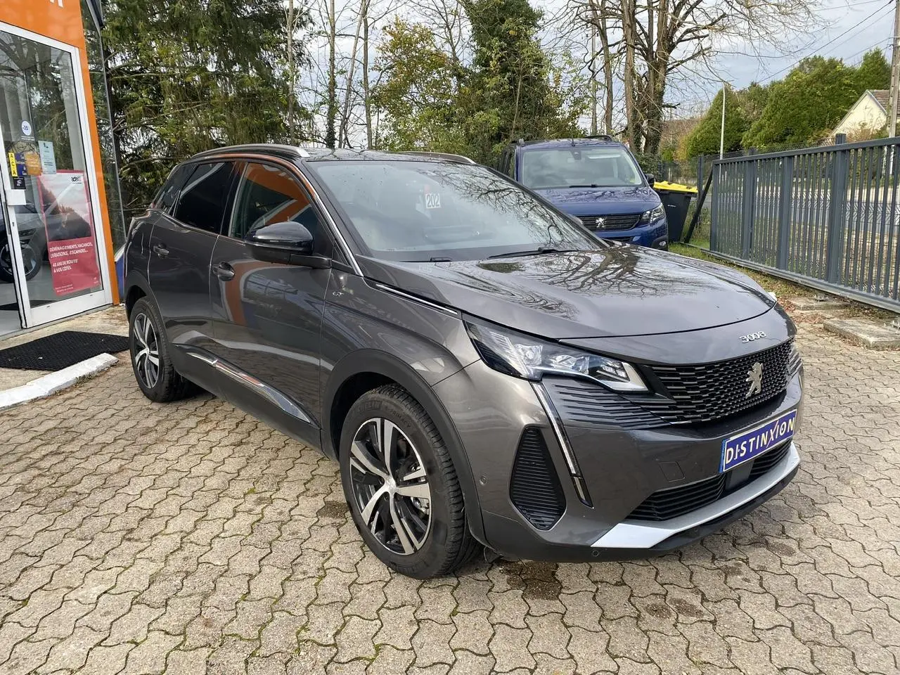 Peugeot 3008 gris foncé vue 3/4 avant, calandre GT chromée et projecteurs Full LED visibles.