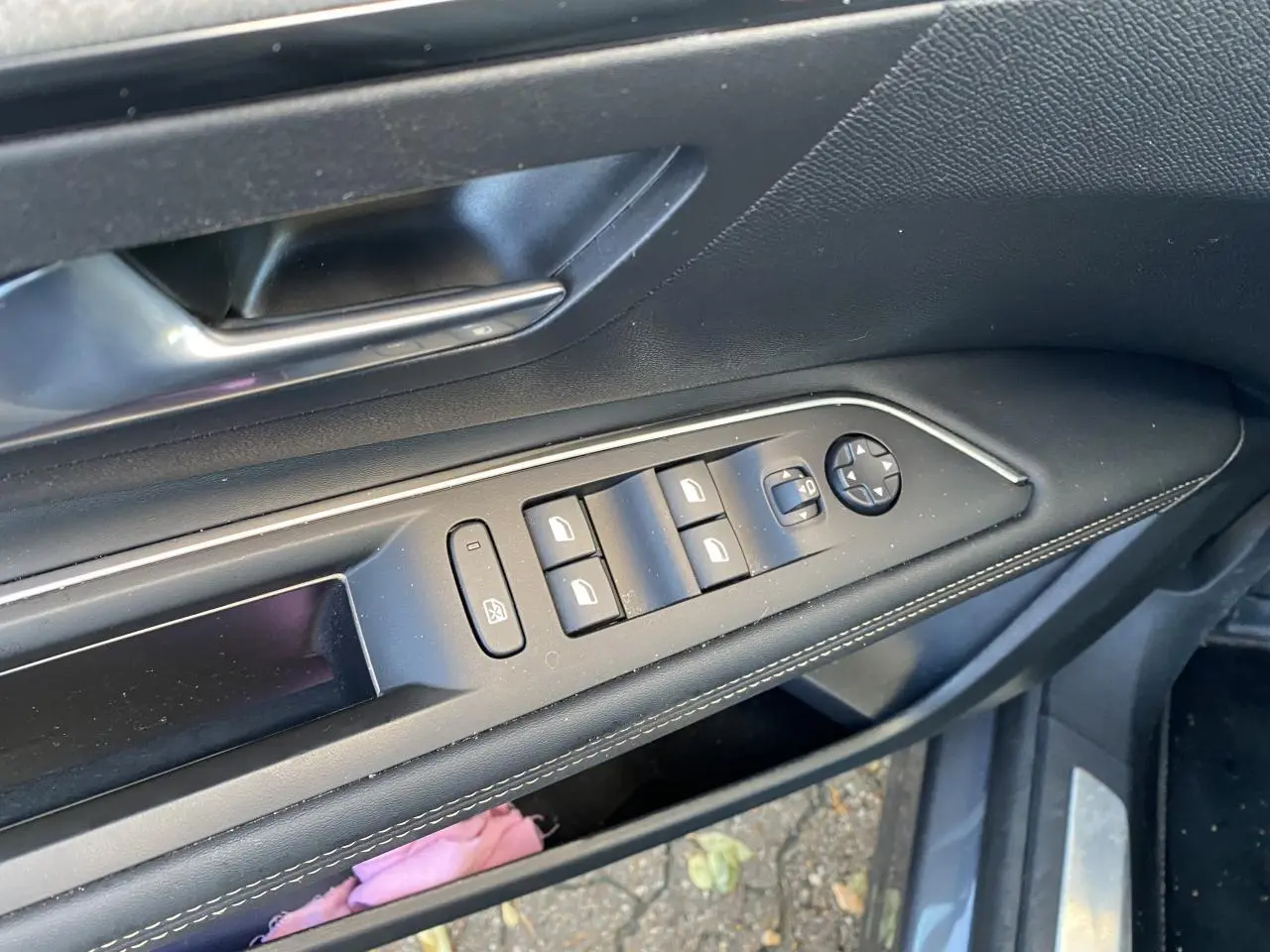 Commande des vitres et rétroviseurs côté conducteur du Peugeot 3008 gris foncé, intérieur noir avec surpiqûres blanches.