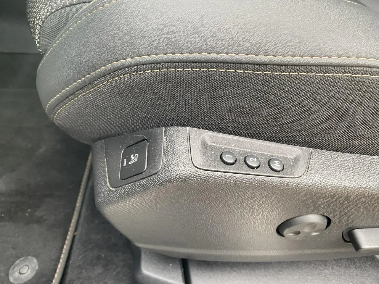 Détail des commandes de réglage mémoire et massage sur le siège avant conducteur du Peugeot 3008 gris foncé.