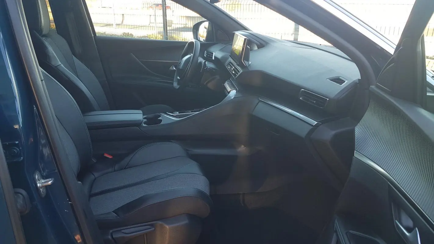 Vue intérieure côté conducteur du Peugeot 5008 bleu 2024, mettant en valeur les sièges réglables et l’écran tactile central.