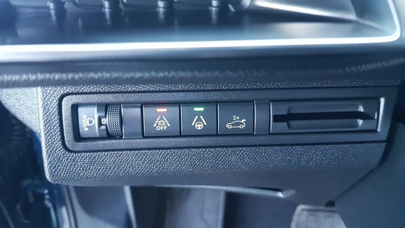 Gros plan sur les commandes d’assistance à la conduite du tableau de bord d’un Peugeot 5008 bleu 2024.