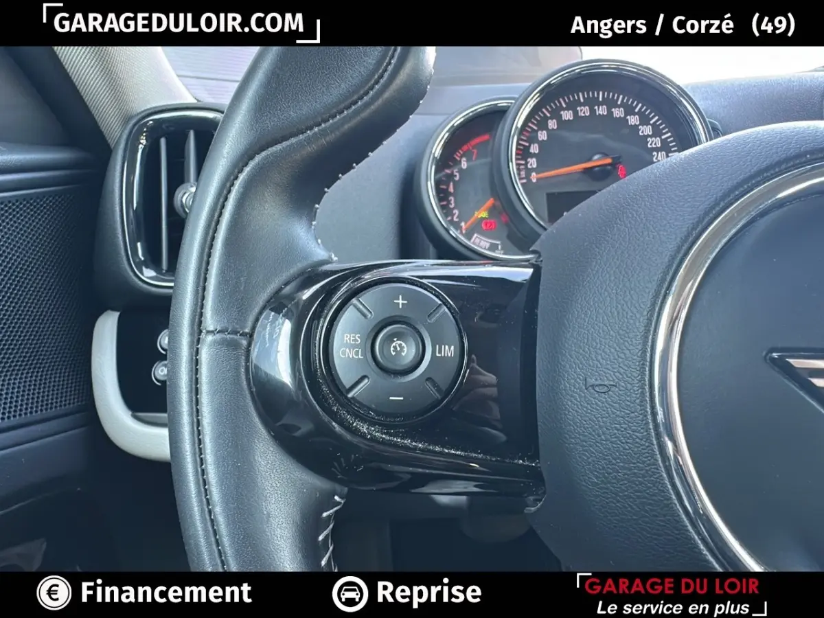 Gros plan sur le volant cuir noir de la MINI Countryman 2020 avec commandes de régulateur de vitesse et tableau de bord partiel.