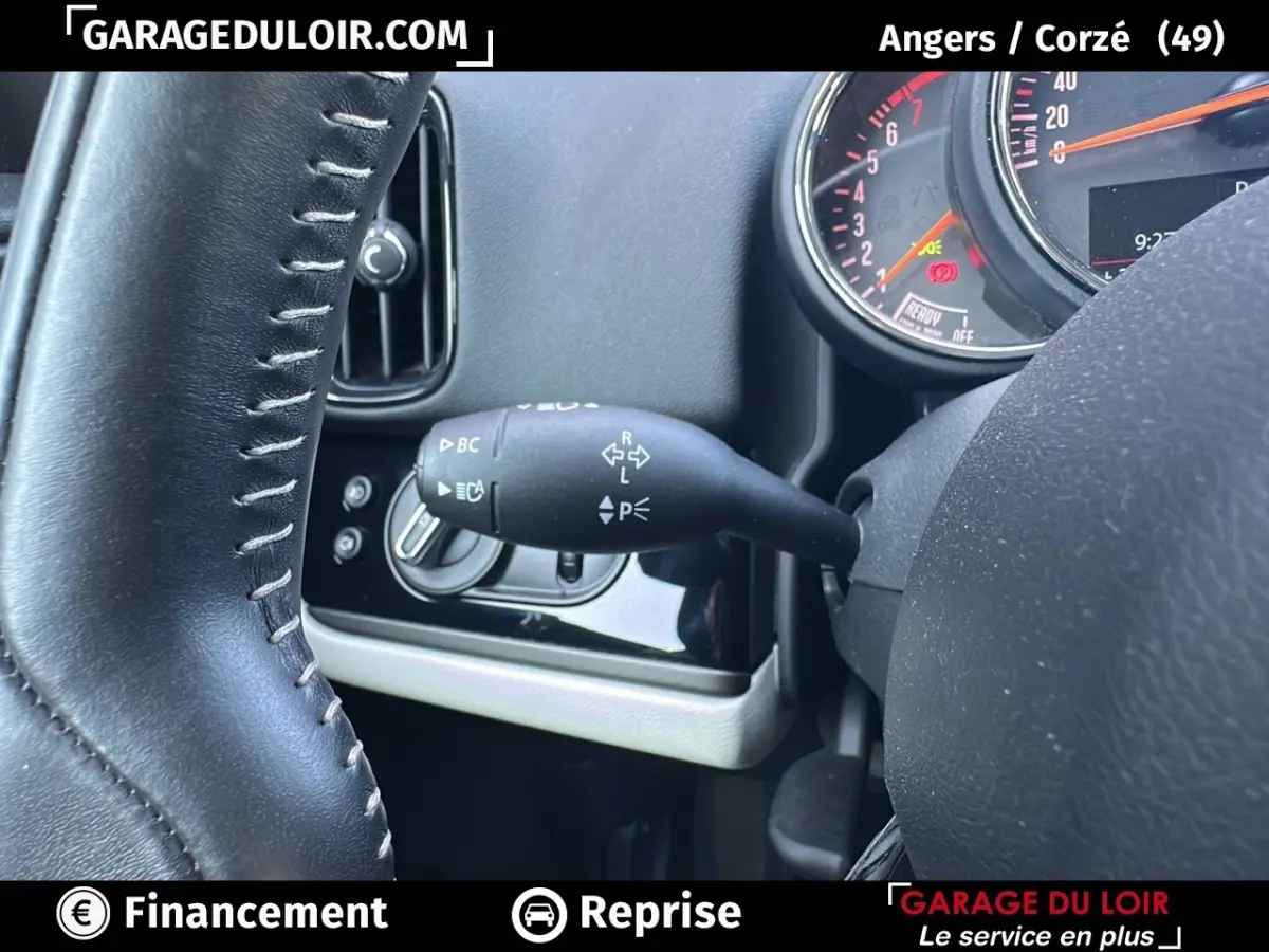 Gros plan sur le commodo de clignotant à gauche du volant cuir noir du tableau de bord MINI Countryman bleu 2020.