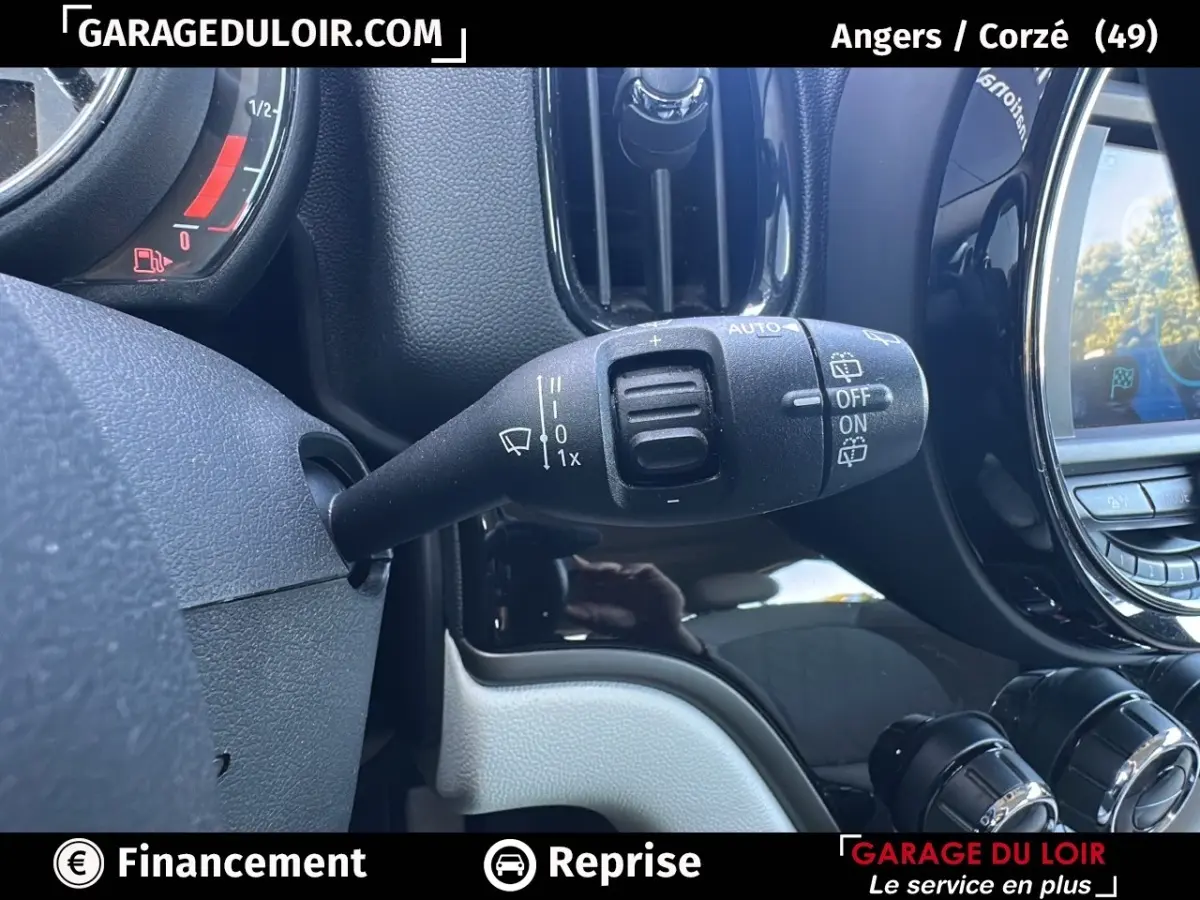 Gros plan sur la commande d'essuie-glace à gauche du volant dans l'habitacle noir et gris d'une MINI Countryman 2020.