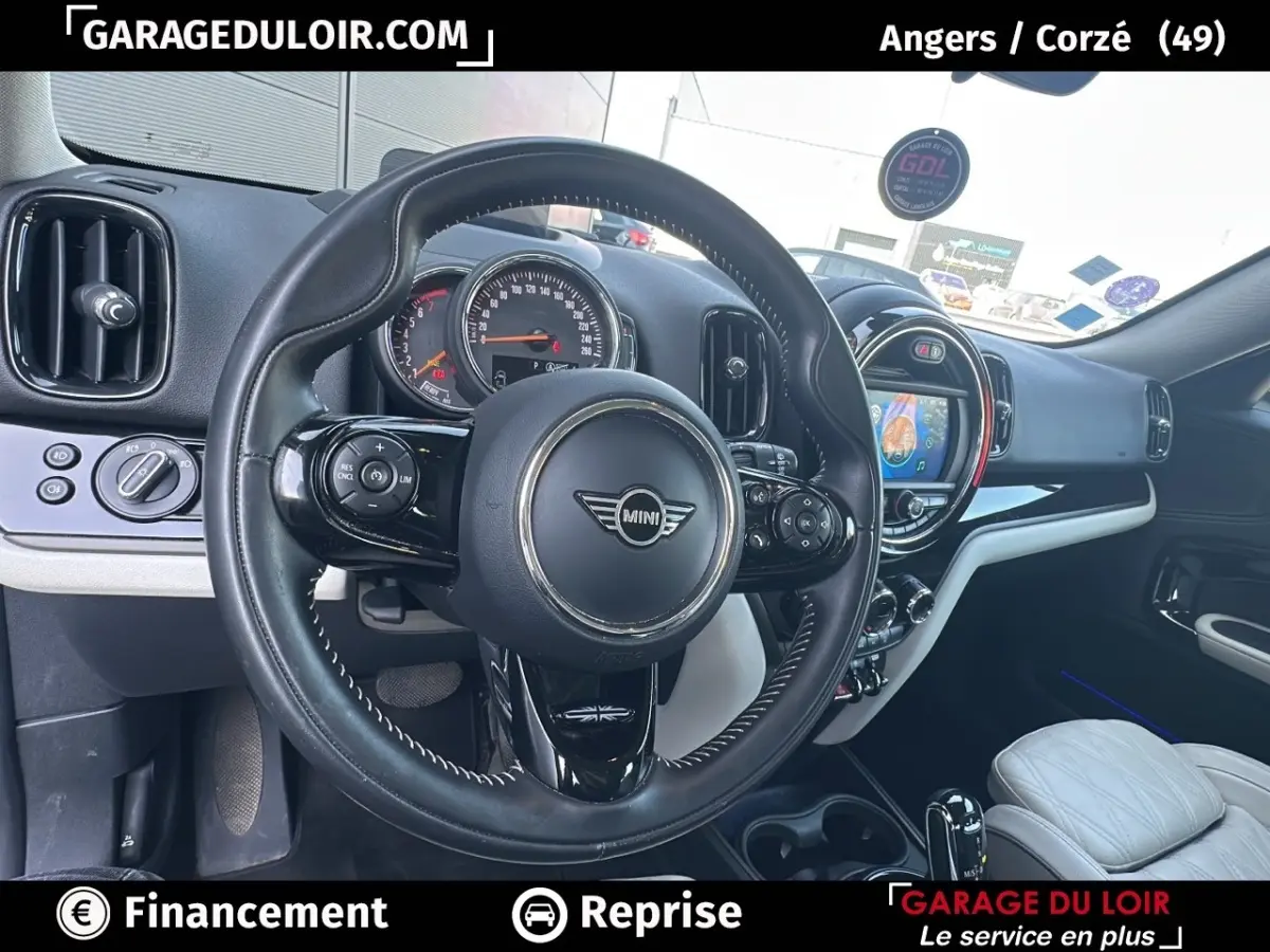 Vue intérieure centrée sur le volant cuir noir et le tableau de bord avec écran tactile du MINI Countryman 2020.