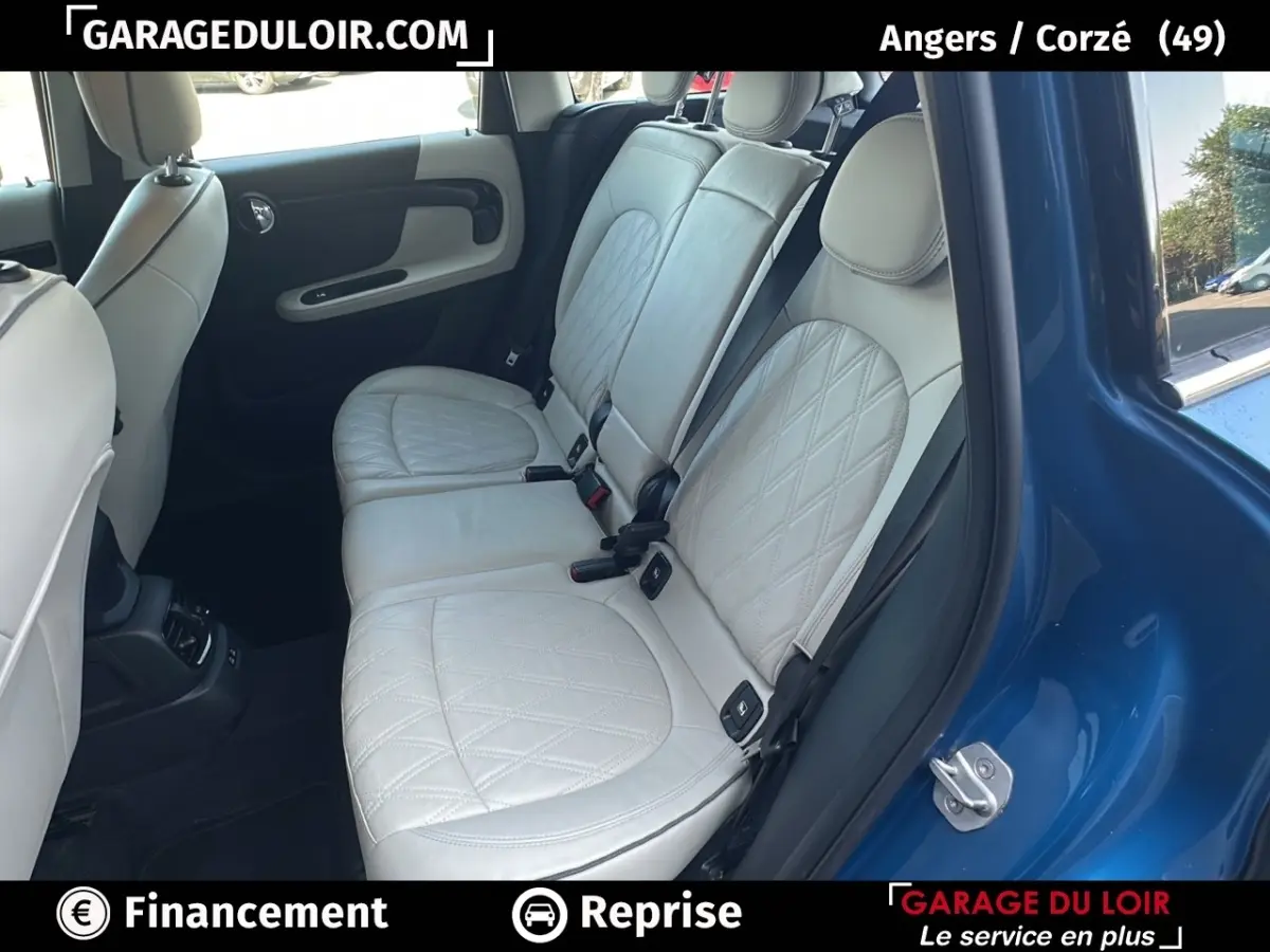 Vue côté droit sur l'intérieur arrière d'une MINI Countryman bleu avec sièges cuir beige matelassés.