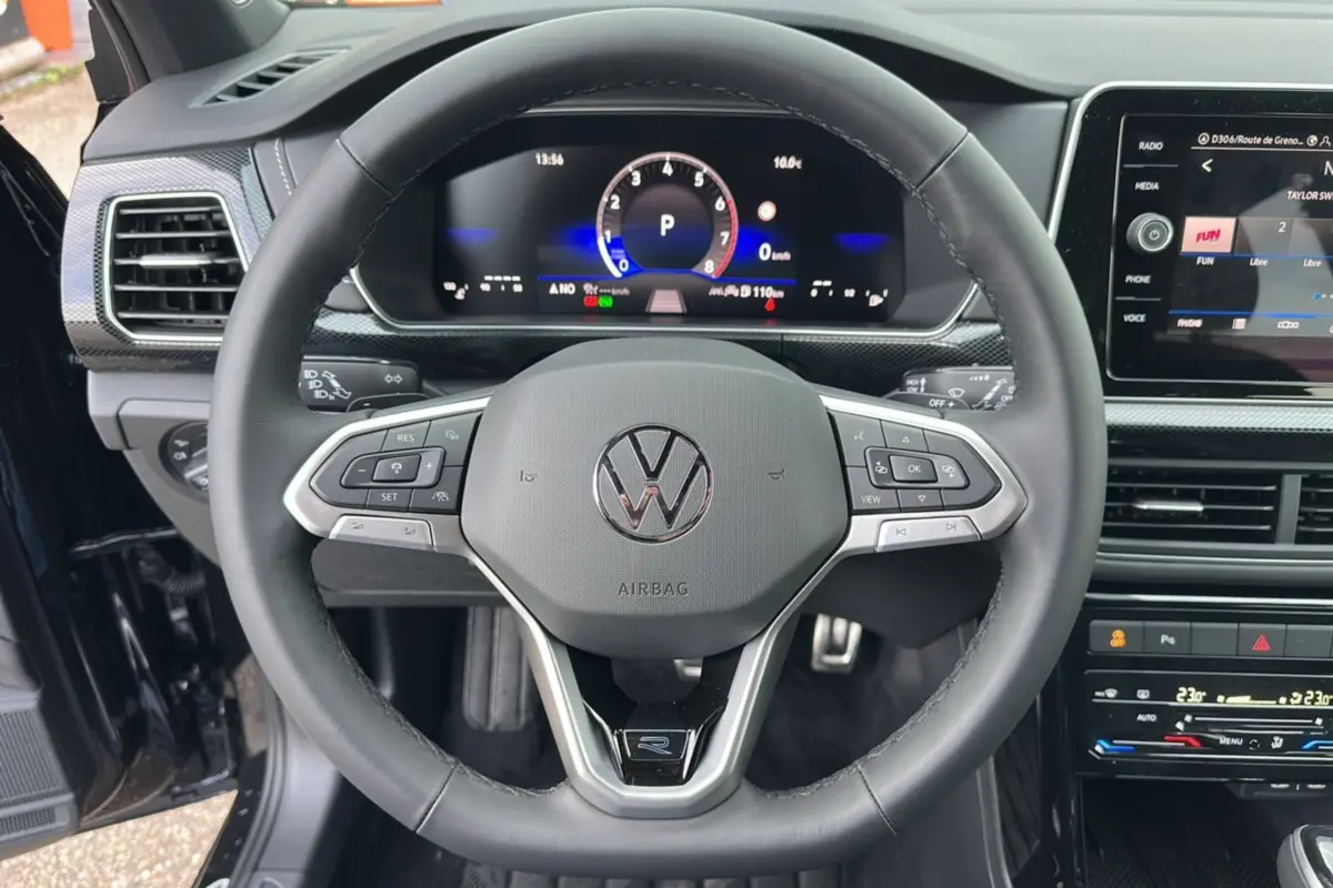 Vue rapprochée du volant cuir multifonctions noir du Volkswagen T-Cross 2025 avec tableau de bord digital et écran central.