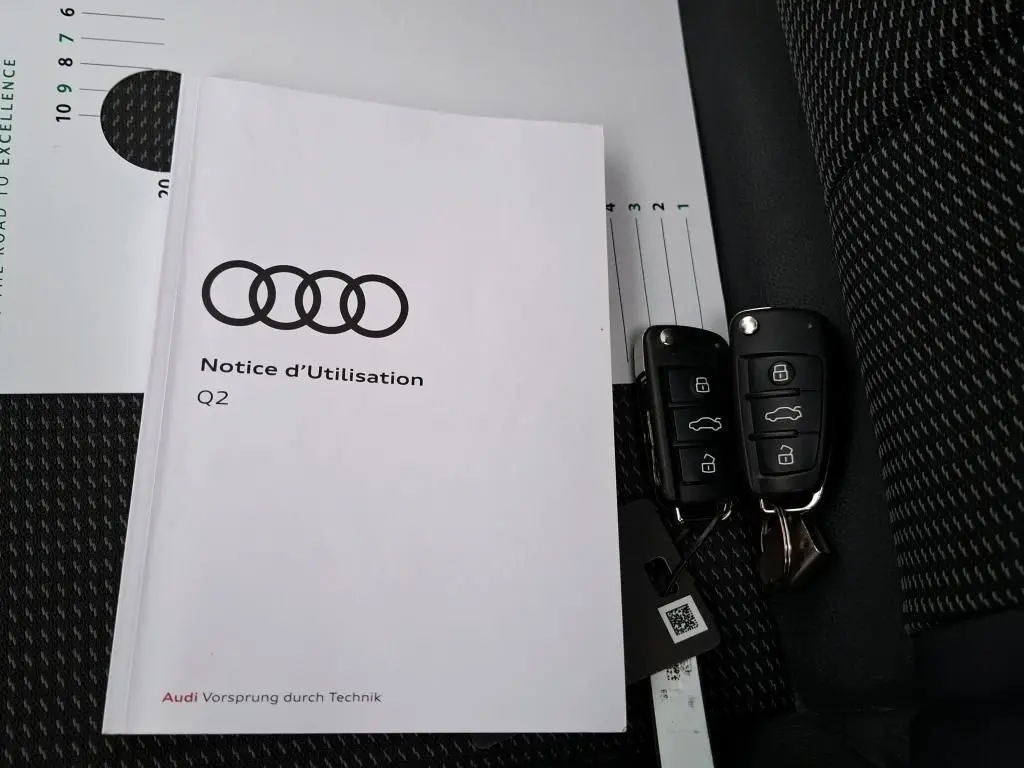 Gros plan sur la porte intérieure côté conducteur noire de l'Audi Q2 2023 avec commandes de vitres et rétroviseurs.