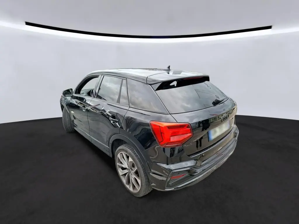 Audi Q2 noir vue de profil côté gauche, avec jantes alliage et intérieur visible à travers les vitres teintées.