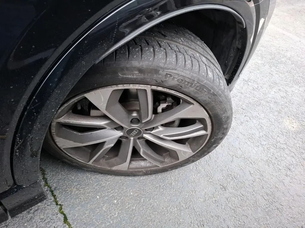 Audi Q2 noir vue 3/4 arrière droit dans un garage, avec jantes alliage et vitres surteintées.