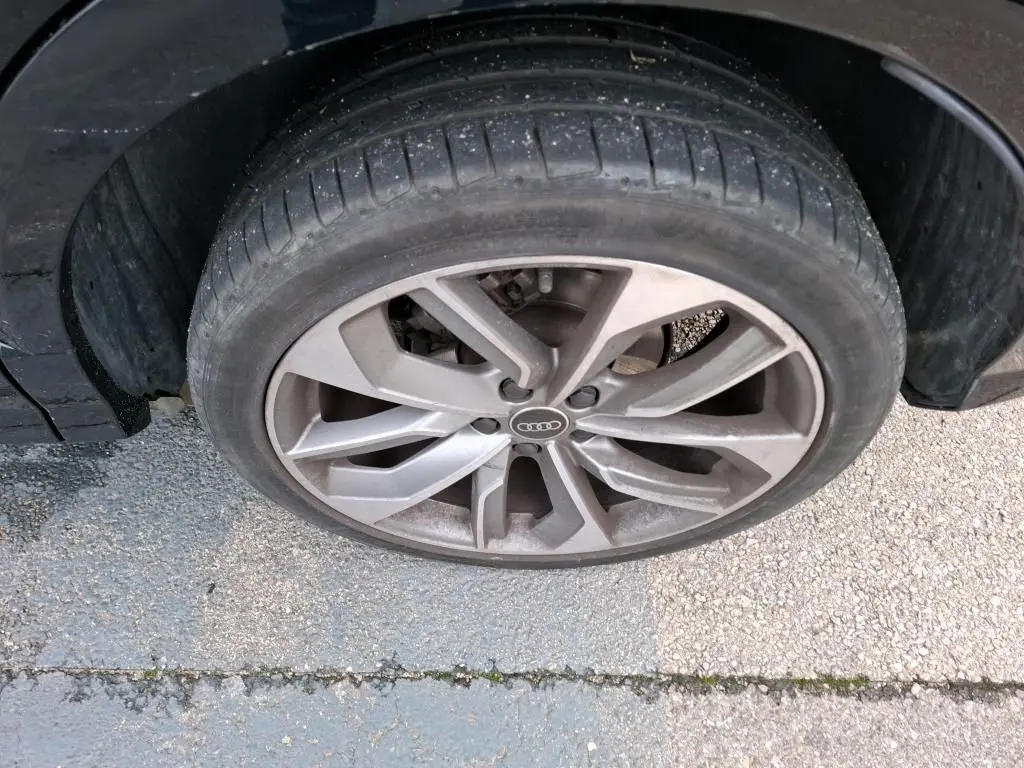 Vue arrière d'un Audi Q2 noir 2023 garé en intérieur avec feux arrière rouges et plaque DISTINXION.