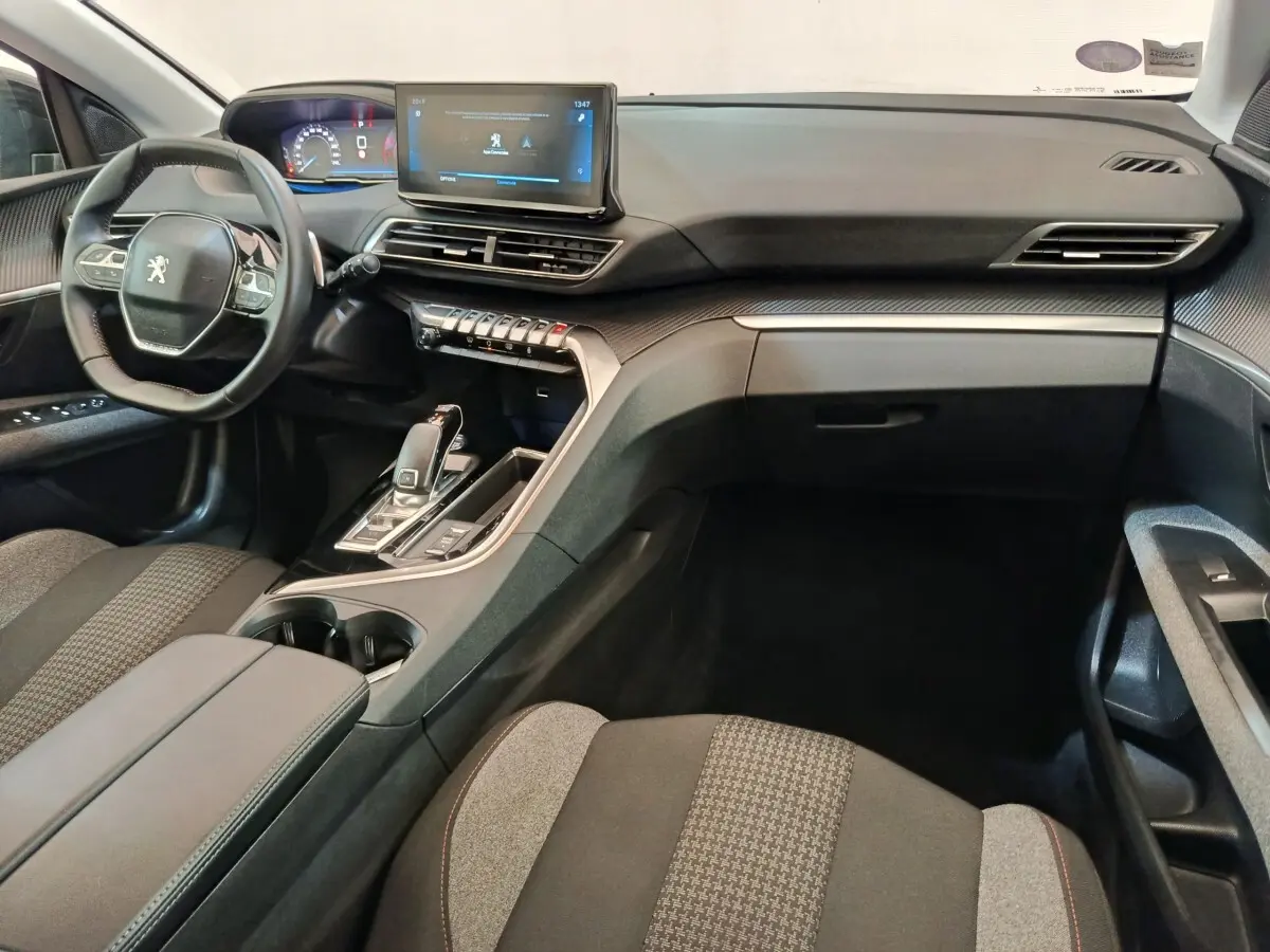 Vue intérieure avant droite du Peugeot 3008 2022, tableau de bord moderne avec écran tactile et volant cuir multifonctions.