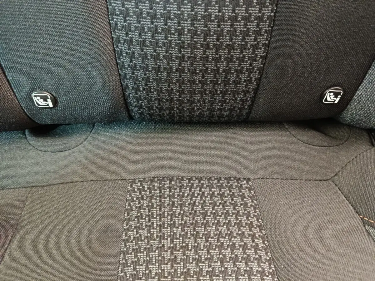 Gros plan sur la banquette arrière noire du Peugeot 3008 avec logos Isofix visibles sur les appuie-têtes.
