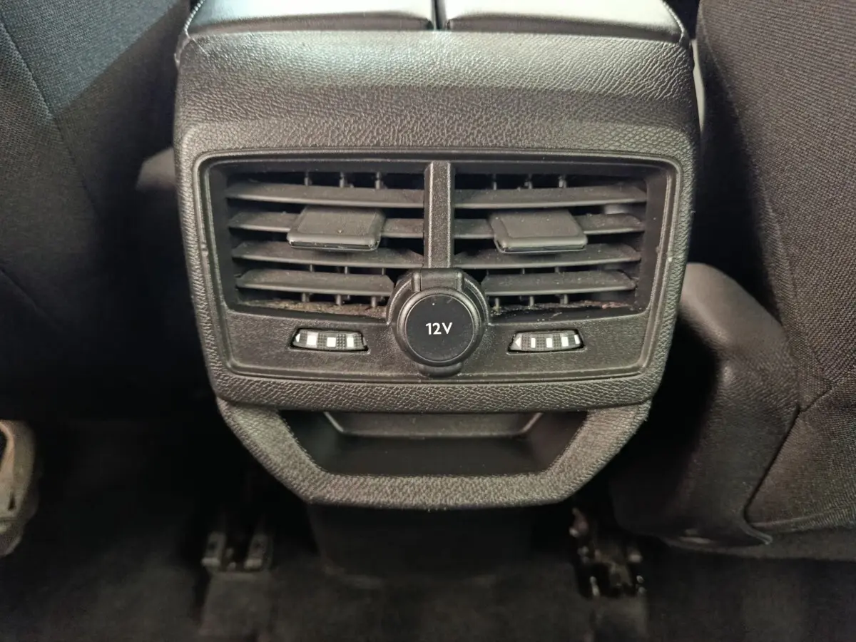Vue rapprochée des bouches de ventilation arrière noires avec prise 12V du Peugeot 3008 gris foncé, version 2022.