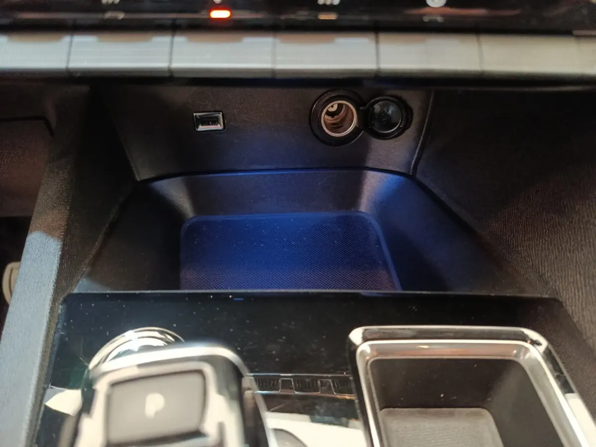 Gros plan sur la console centrale noire du Peugeot 3008 gris foncé, avec prise USB et allume-cigare visibles.