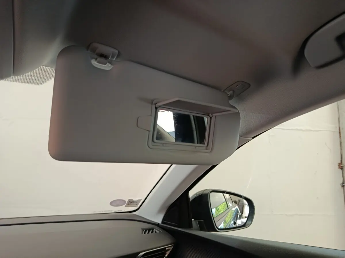 Intérieur du Peugeot 3008 gris foncé, vue côté passager avec pare-soleil abaissé et miroir de courtoisie ouvert.