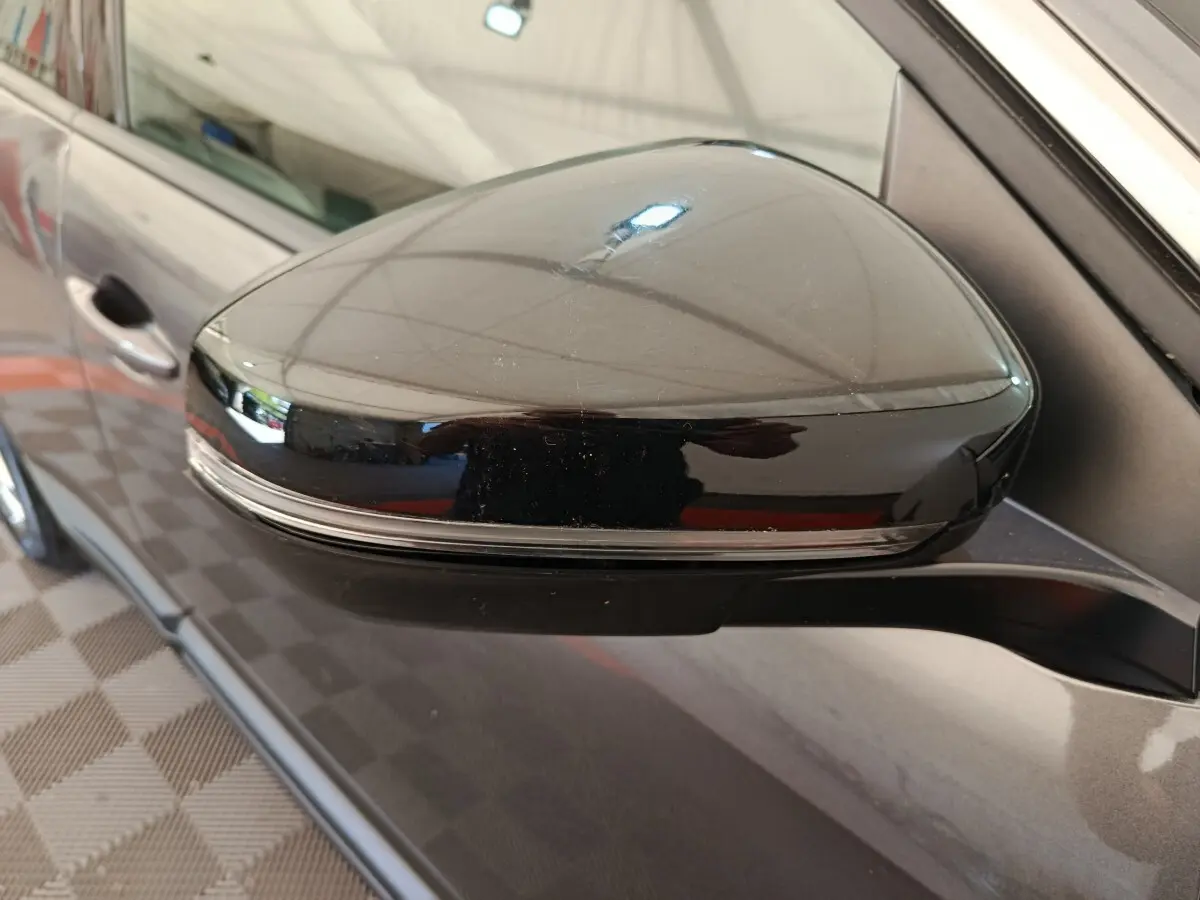 Rétroviseur droit noir brillant avec clignotant intégré sur Peugeot 3008 gris foncé, vue rapprochée côté passager.