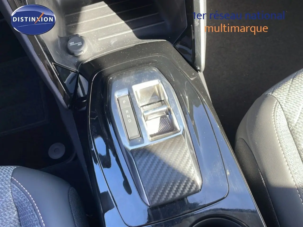 Vue rapprochée de la console centrale noire brillante avec sélecteur de boîte automatique sur Peugeot 208 jaune Agueda Metal.